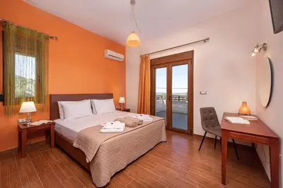 a bedroom with a bed and a desk and a chair at Vlasis' Eden Villa - Islander's Home Collection in Sálakos