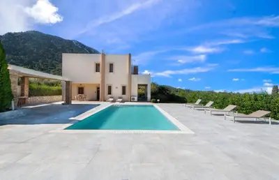 a villa with a swimming pool in front of a house at Vlasis' Eden Villa - Islander's Home Collection in Sálakos