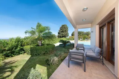 a patio with chairs and a view of the ocean at Vlasis' Eden Villa - Islander's Home Collection in Sálakos