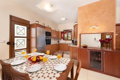 a kitchen with a table with fruit on it at Vlasis' Eden Villa - Islander's Home Collection in Sálakos