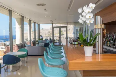 a restaurant with chairs and a bar with a view at Lindos Blu Luxury Hotel-Adults only in Líndos