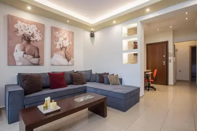 a living room with a blue couch and a table at Anita Luxury Apartment in Rhodes Town
