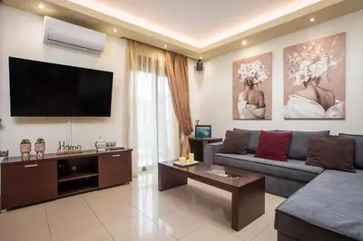 a living room with a couch and a flat screen tv at Anita Luxury Apartment in Rhodes Town