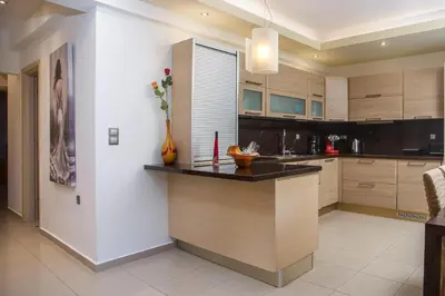 a kitchen with wooden cabinets and a counter top at Anita Luxury Apartment in Rhodes Town