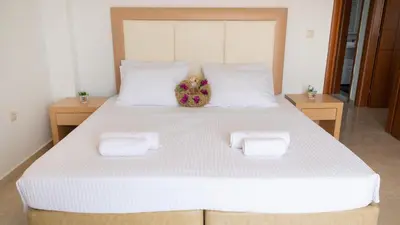a large white bed with two towels on it at Naelia in Pastida