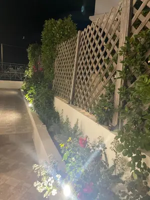 a garden with flowers and a fence at night at Naelia in Pastida