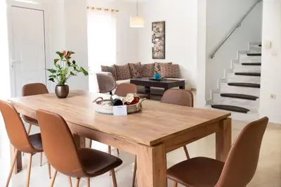 a dining room with a wooden table and chairs at Naelia in Pastida