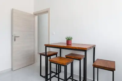 a table and two stools in a room with a door at Mailo&Luke apartments in Rhodes Town