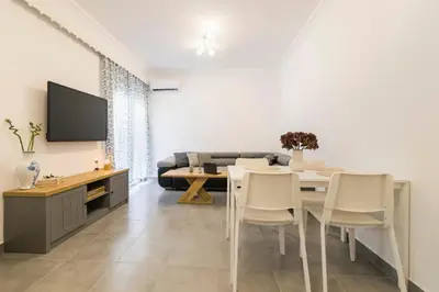 a living room with a table and a tv at Mailo&Luke apartments in Rhodes Town