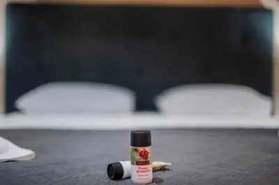 a bottle of lipstick sitting on a bed at Villa Eleni in Soroni