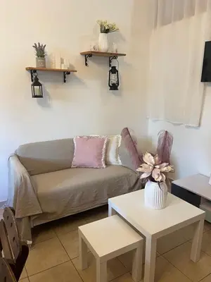 a living room with a couch and two tables at Irene’s house in Koskinou