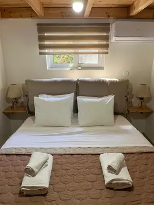 a bed in a room with two pillows and a window at Irene’s house in Koskinou