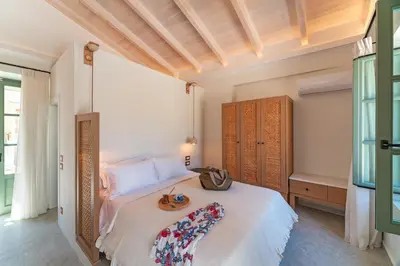 a bedroom with a large white bed in a room at Nisomar Suites in Symi