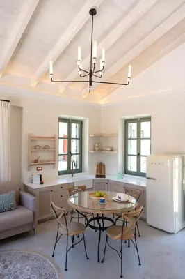 a kitchen with a table and chairs in a room at Nisomar Suites in Symi