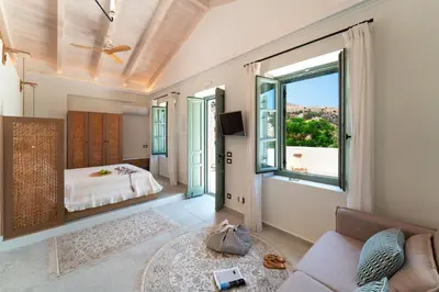 a living room with a bed and a large window at Nisomar Suites in Symi