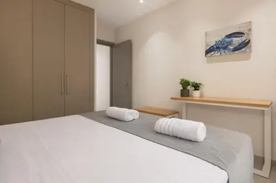 a bedroom with a white bed with two towels on it at Stylish Rhodes Apartment with Prime Location - L & C City Escape in Rhodes Town