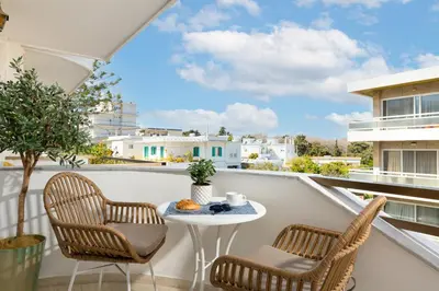 a balcony with a table and chairs and a view at Stylish Rhodes Apartment with Prime Location - L & C City Escape in Rhodes Town