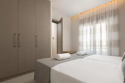 a bedroom with two beds and a large window at Stylish Rhodes Apartment with Prime Location - L & C City Escape in Rhodes Town