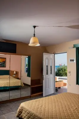 a bedroom with a bed and a large mirror at Limanaki Seafront Apartments in Faliraki