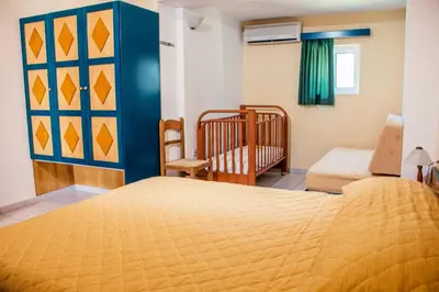 a bedroom with two beds and a crib at Limanaki Seafront Apartments in Faliraki