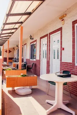 a room with a table and chairs and a brick wall at Limanaki Seafront Apartments in Faliraki