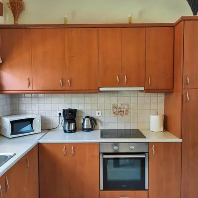 a kitchen with wooden cabinets and a stove top oven at Bellavista House in Monolithos Rhodes in Monólithos