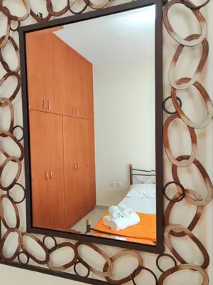 a mirror on a wall with a bed in a room at Bellavista House in Monolithos Rhodes in Monólithos