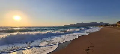 a beach with the sun rising over the ocean at Ospition Villa in Apolakkiá