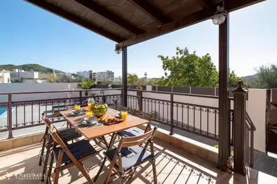 a table and chairs on a balcony with a view at Ospition Villa in Apolakkiá