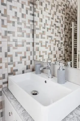 a white sink in a bathroom with a tiled wall at Kastrena House in Asklipiḯon