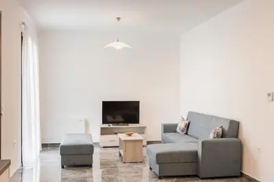 a living room with a couch and a tv at Kastrena House in Asklipiḯon