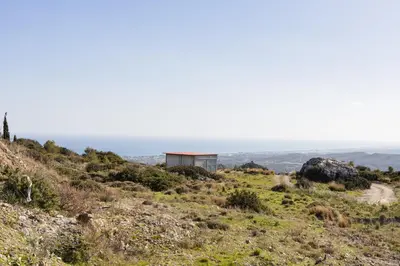 a house on a hill with the ocean in the background at Kastrena House in Asklipiḯon