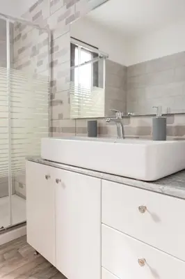 a white bathroom with a sink and a mirror at Kastrena House in Asklipiḯon