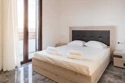 a bedroom with a large bed with two towels on it at Kastrena House in Asklipiḯon