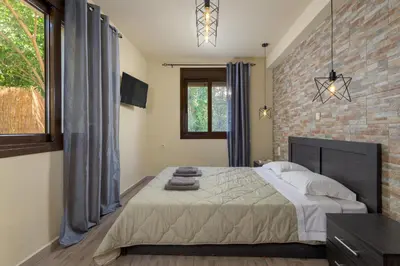 a bedroom with a bed and a brick wall at Parko Studios in Rhodes Town