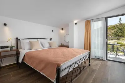 a bedroom with a large bed and a balcony at Aiora Luxury Villas in Afantou