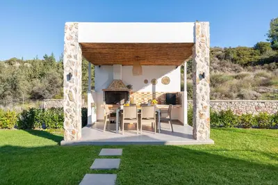a gazebo with a table and chairs in a yard at Aiora Luxury Villas in Afantou