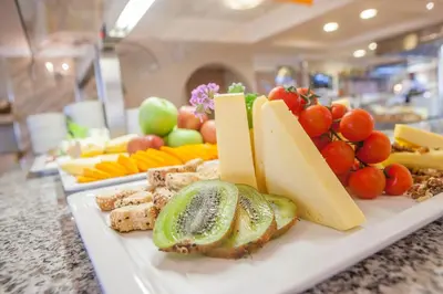 a plate of cheese and fruits and vegetables on a counter at IALYSSOS BAY HOTEL in Ialyssos