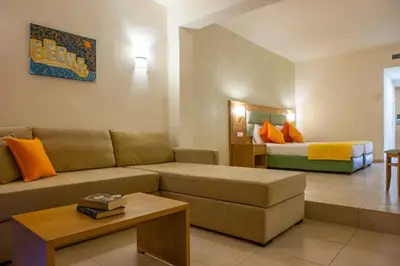 a living room with a couch and a bed at IALYSSOS BAY HOTEL in Ialyssos