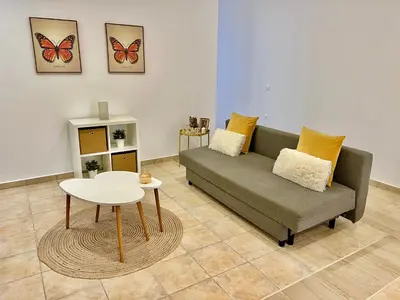 a living room with a couch and a table at Cute & sweet home in Archangelos