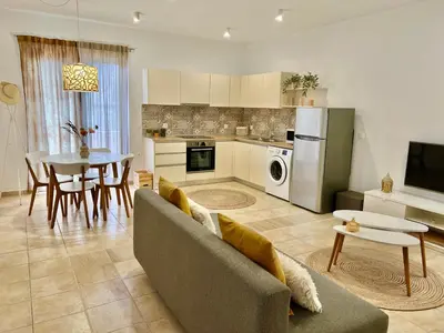 a kitchen and living room with a couch and a table at Cute & sweet home in Archangelos