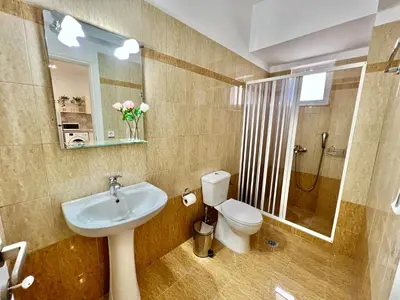 a bathroom with a sink and a toilet and a mirror at Cute & sweet home in Archangelos