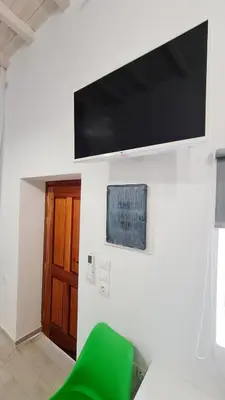 a living room with a green chair and a flat screen tv at Lefko House in Lachania