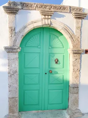 a green door in a building with an arch at Lefko House in Lachania