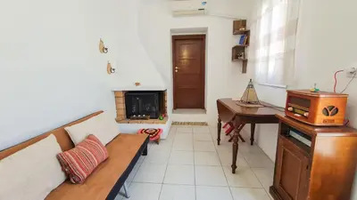 a living room with a couch and a table and a fireplace at Lefko House in Lachania