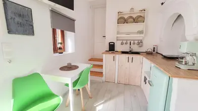 a kitchen with a table and a green chair at Lefko House in Lachania