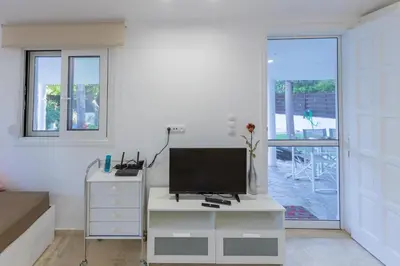 a living room with a tv on a white dresser at Katerlove Beach House in Faliraki