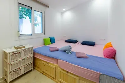two twin beds in a room with a window at Katerlove Beach House in Faliraki