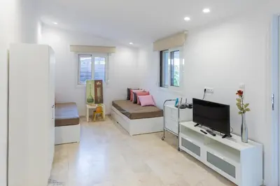 a living room with two beds and a television at Katerlove Beach House in Faliraki