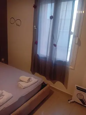 a bedroom with a bed and a shower with a curtain at IRINIS HOUSES in Rhodes Town